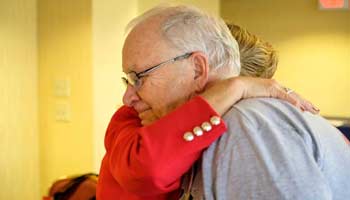 Older man being hugged