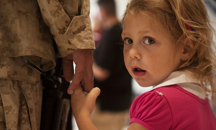 little girl holding soldier's hand