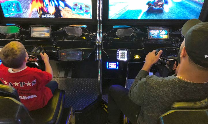 TAPS boy and adult playing at an arcade