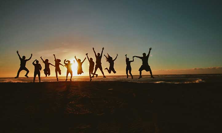 happy friends against sunset