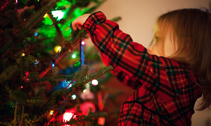 Child decorating Christmas tree