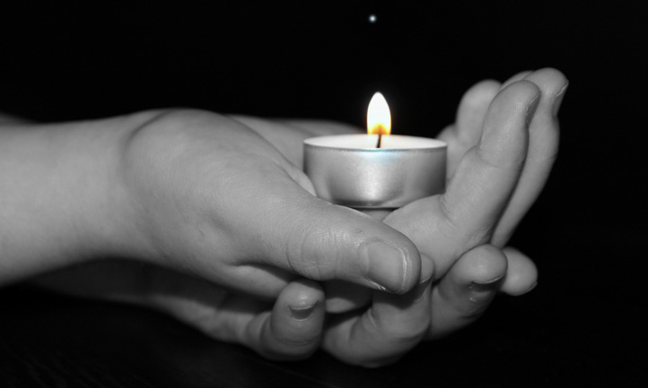 Hands holding tealight