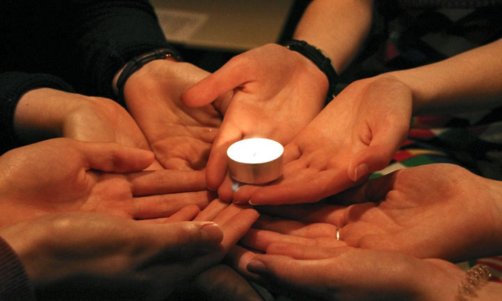 friend holding a tealight together