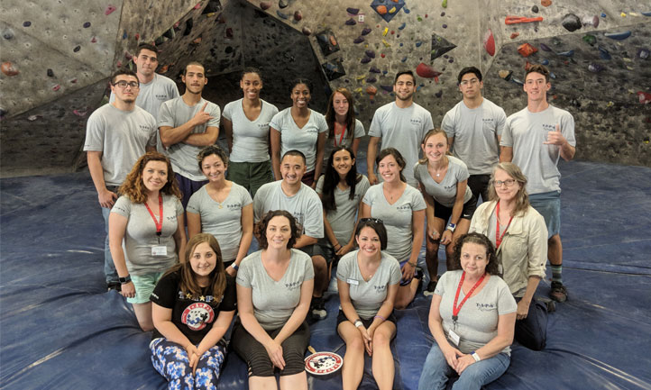 Young adult survivors challenge themselves to climb rock walls at a retreat in Austin, Texas.
