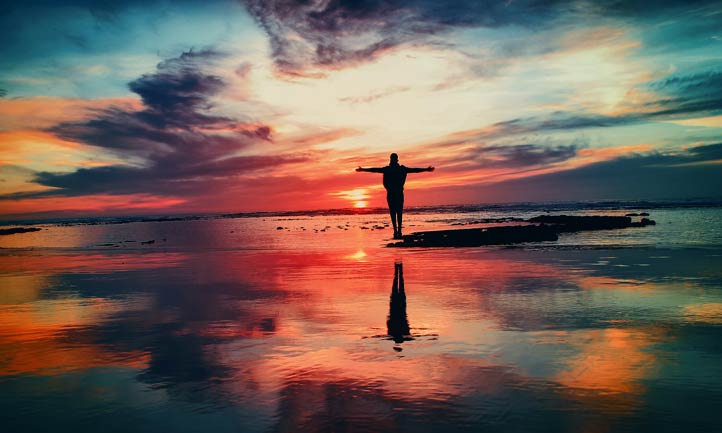 Man reaching out to colorful horizon