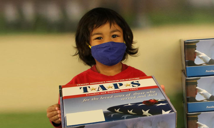 TAPS March Newsletter 2021 cover, Young child packing resourse kits