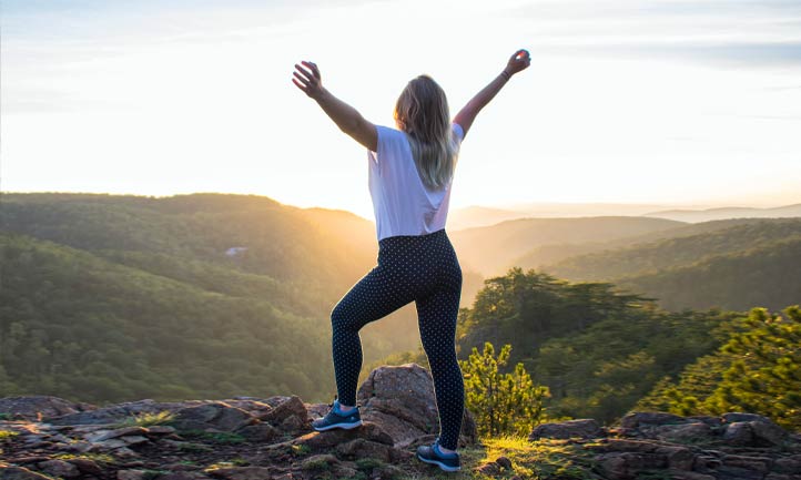 Woman looking out with arms outstretched