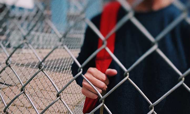 Student at chain link fence