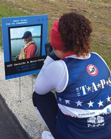 Ideliz looking at andre memorial marker at Team TAPS event