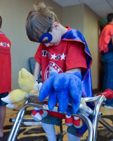 Child using walker in Superhero costume