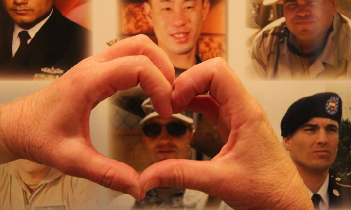 TAPS February Newsletter 2023, Survivor makes heart around loved one photo with her hands
