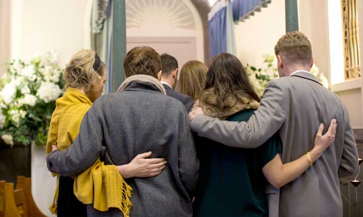 Mourners embrace at funeral