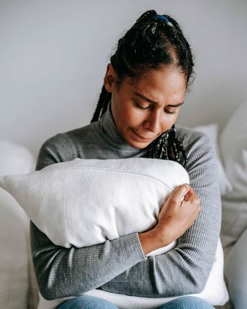 Sad woman holding pillow