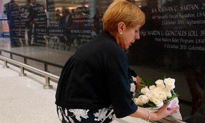 Maria Gonzales lays flowers at war memorial at Miami Airport